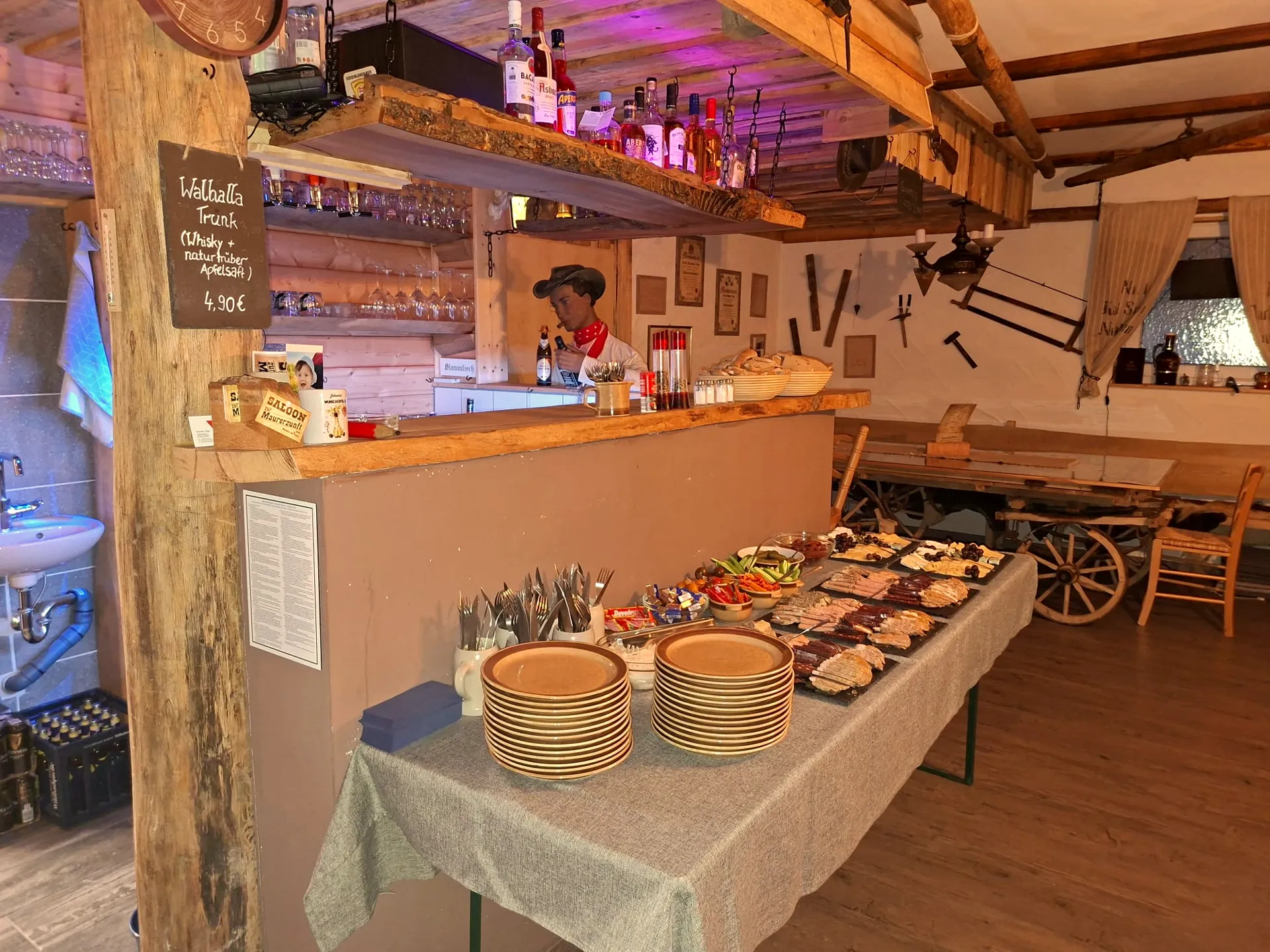 Saloon-Theke mit aufgebautem Buffet, Cowboy-Figur und Kreidetafel